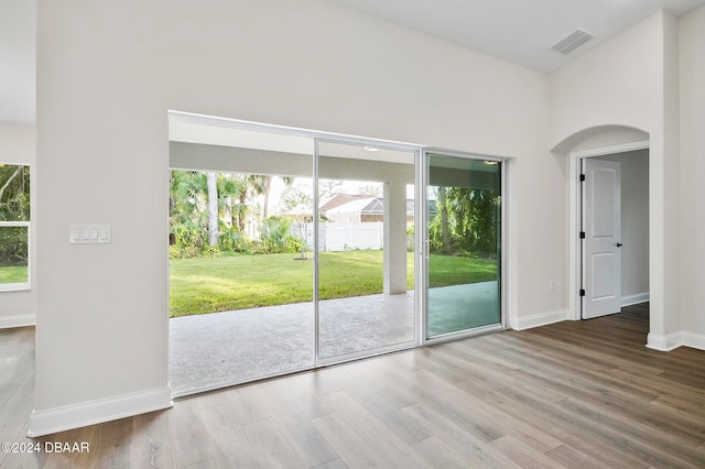 doorway to outside with a high ceiling and hardwood / wood-style floors