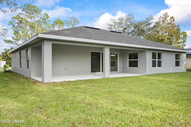 rear view of house featuring a patio and a yard