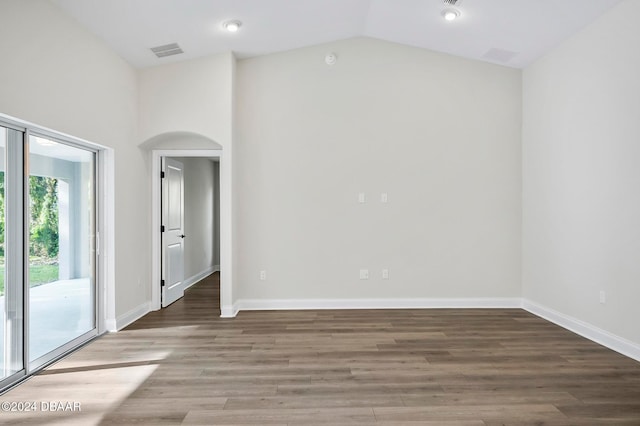 spare room featuring hardwood / wood-style floors and vaulted ceiling