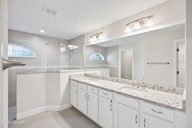 bathroom with vanity, tile patterned floors, and a tile shower