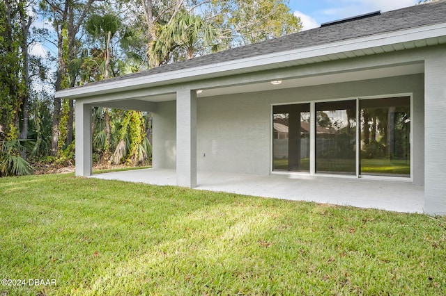 back of house with a patio and a yard