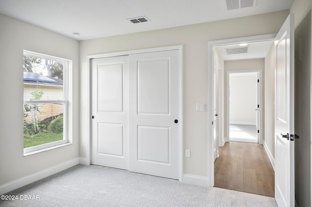 unfurnished bedroom featuring a closet and light hardwood / wood-style floors