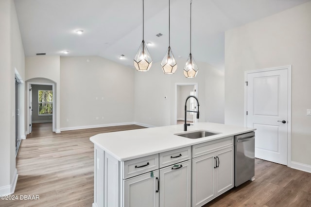 kitchen with stainless steel dishwasher, sink, hardwood / wood-style flooring, and a kitchen island with sink