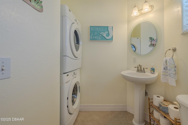 washroom featuring stacked washer / dryer and sink