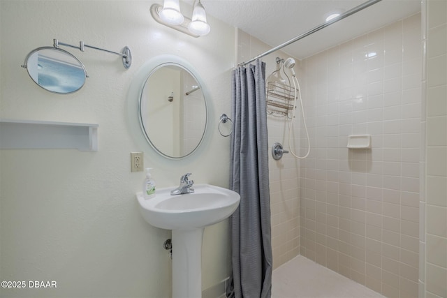 bathroom with a shower with shower curtain and a textured ceiling