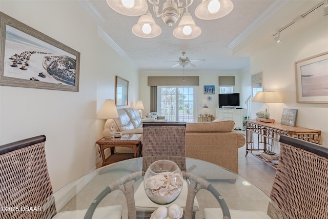 dining space featuring a textured ceiling, ceiling fan with notable chandelier, rail lighting, and ornamental molding