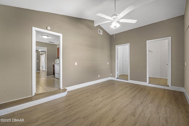 unfurnished bedroom with ceiling fan, vaulted ceiling, and light hardwood / wood-style flooring