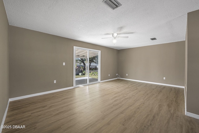 unfurnished room with hardwood / wood-style flooring, ceiling fan, and a textured ceiling