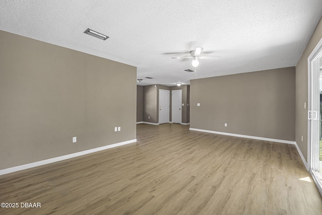 spare room featuring ceiling fan, light hardwood / wood-style floors, and a textured ceiling