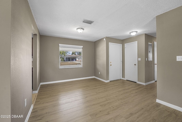 spare room featuring a textured ceiling and light wood-type flooring