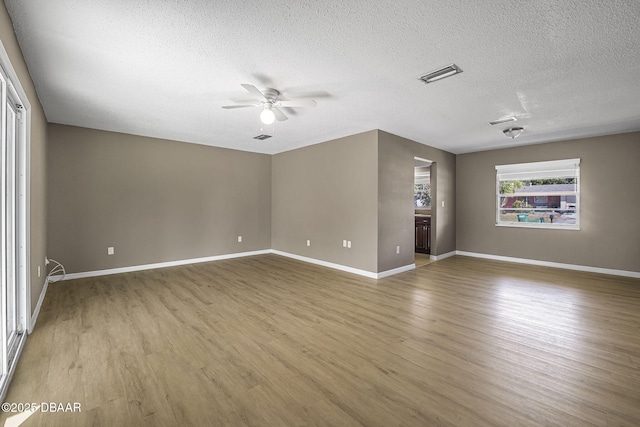 unfurnished living room featuring ceiling fan, hardwood / wood-style floors, and a textured ceiling