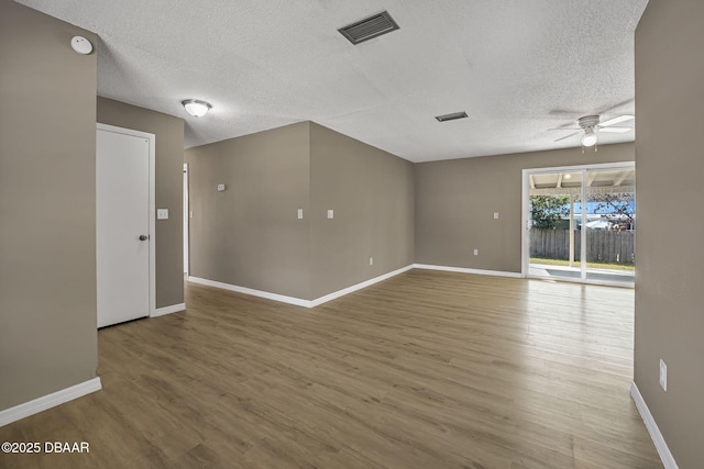 unfurnished room featuring ceiling fan, hardwood / wood-style flooring, and a textured ceiling