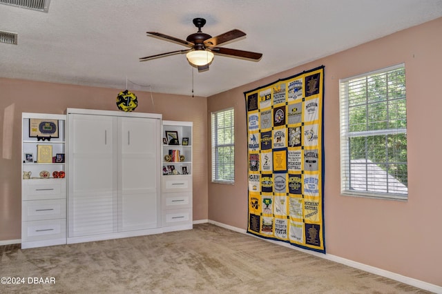 interior space featuring a ceiling fan, visible vents, a textured ceiling, and baseboards