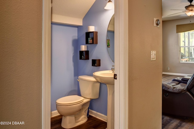 half bath featuring toilet, ceiling fan, baseboards, and wood finished floors