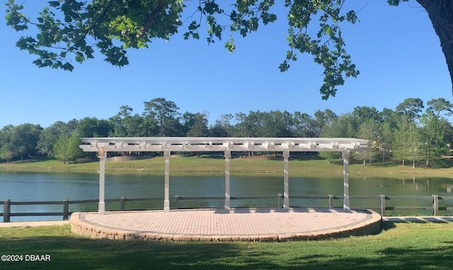 dock area featuring a water view, fence, and a lawn