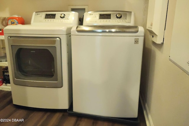 laundry area with laundry area, washer and clothes dryer, and dark wood-style flooring