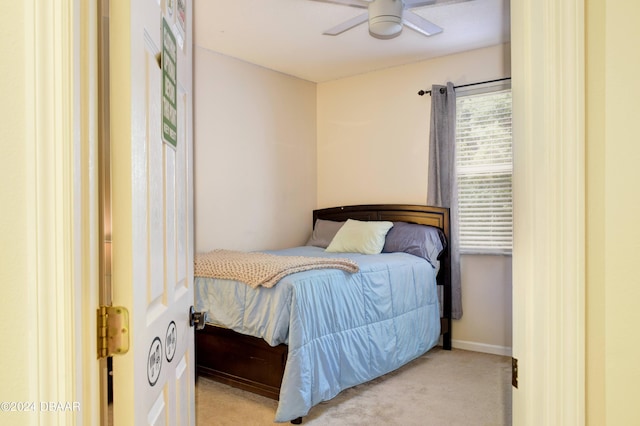 carpeted bedroom with ceiling fan and baseboards