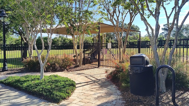 view of home's community featuring playground community and fence