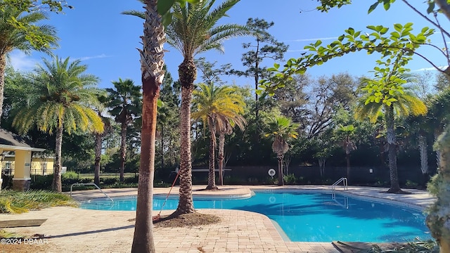 pool featuring fence and a patio