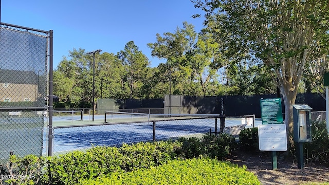 view of tennis court featuring fence