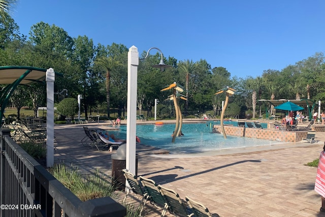 view of jungle gym with a community pool and fence