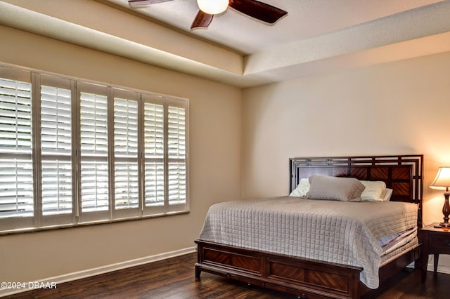 bedroom with a ceiling fan, baseboards, and wood finished floors