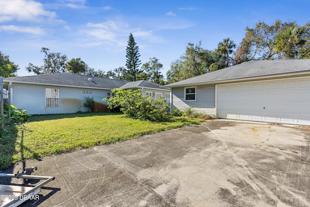 ranch-style house featuring a garage and a front lawn