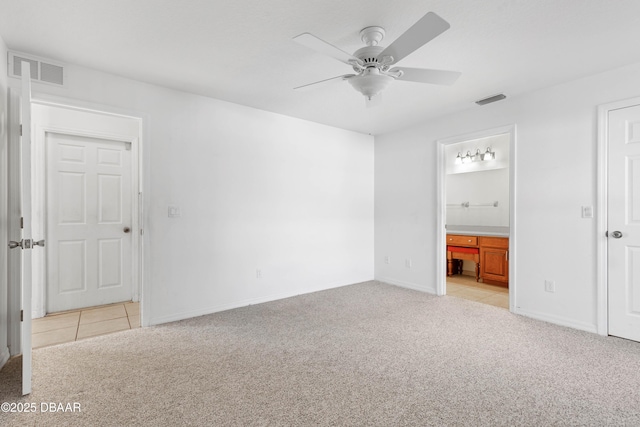 unfurnished bedroom with light carpet, ceiling fan, and ensuite bath