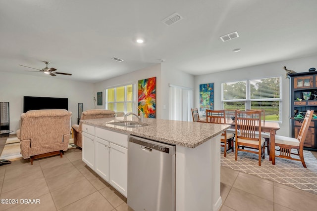 kitchen with dishwasher, white cabinets, sink, a kitchen island with sink, and light stone countertops