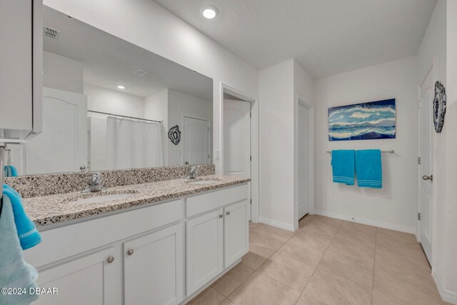 350 Sunset Point Dr, Ormond Beach, FL 32174 - bathroom featuring double vanity, baseboards, tile patterned floors, and a shower with curtain