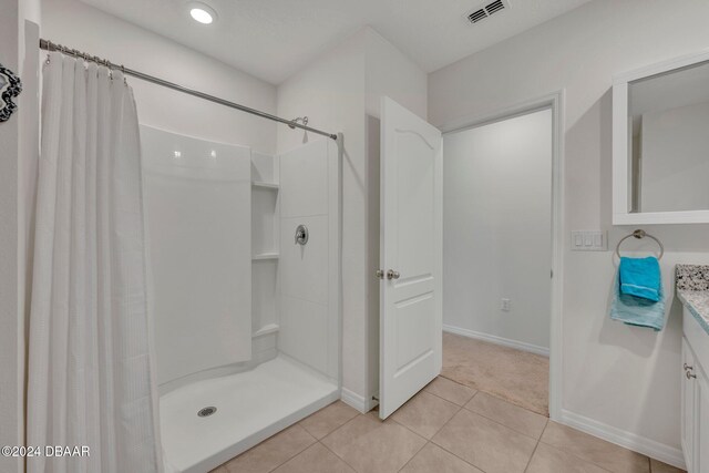 350 Sunset Point Dr, Ormond Beach, FL 32174 - full bathroom featuring vanity, a shower with shower curtain, tile patterned floors, and baseboards