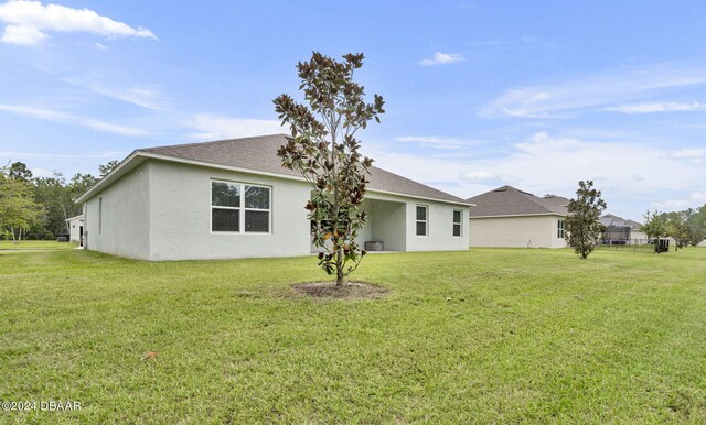 350 Sunset Point Dr, Ormond Beach, FL 32174 - back of house featuring stucco siding, a yard, and roof with shingles