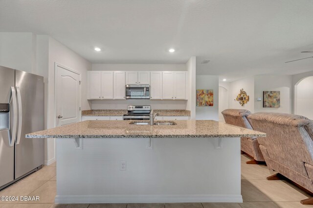 350 Sunset Point Dr, Ormond Beach, FL 32174 - kitchen with stainless steel appliances, a sink, a breakfast bar, light stone countertops, and recessed lighting