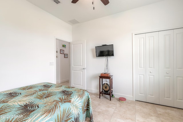 bedroom with a closet, light tile patterned floors, and ceiling fan