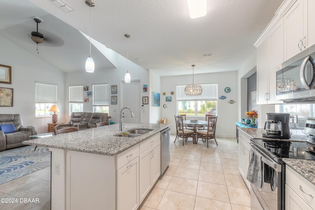 kitchen with stainless steel appliances, white cabinetry, a center island with sink, and a healthy amount of sunlight