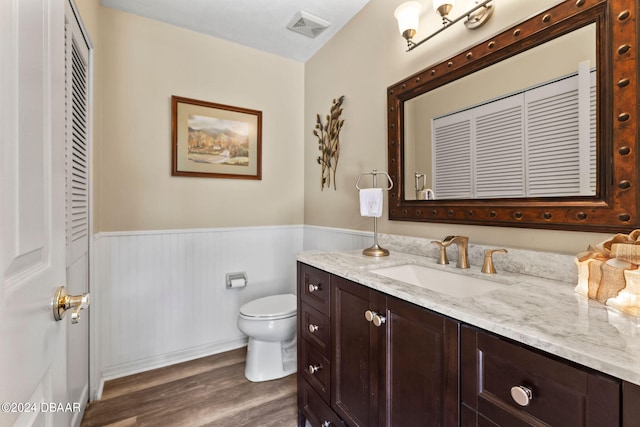 bathroom with hardwood / wood-style floors, vanity, and toilet