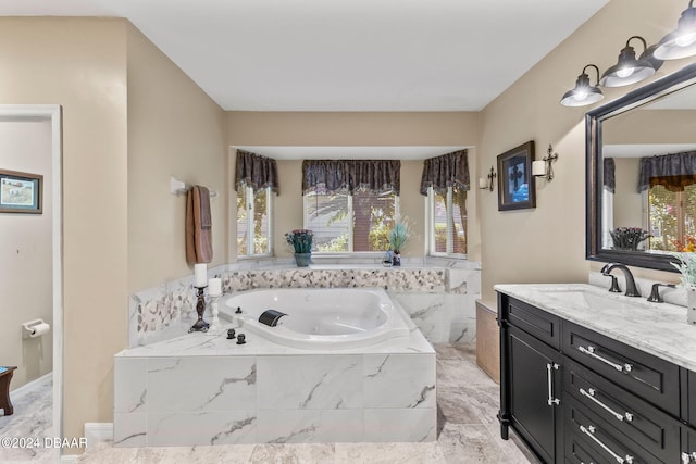 bathroom featuring a relaxing tiled tub and vanity