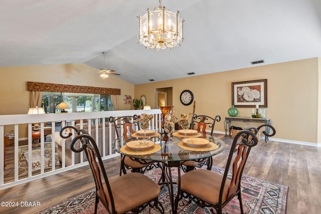 dining space with hardwood / wood-style floors, ceiling fan with notable chandelier, and vaulted ceiling