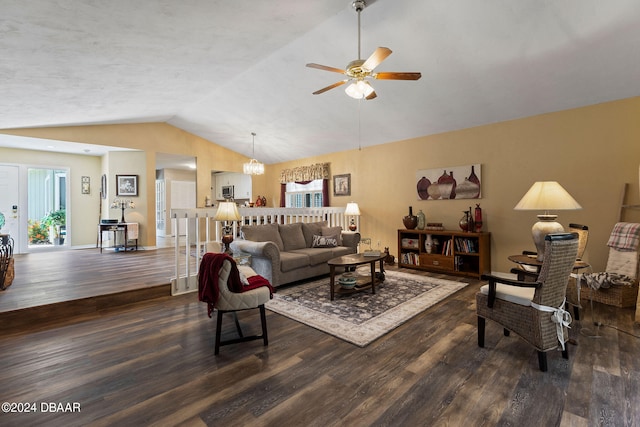 living room featuring dark wood-type flooring, ceiling fan with notable chandelier, and vaulted ceiling