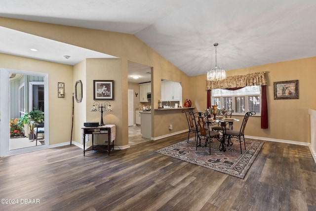 dining area featuring dark hardwood / wood-style flooring, vaulted ceiling, and an inviting chandelier