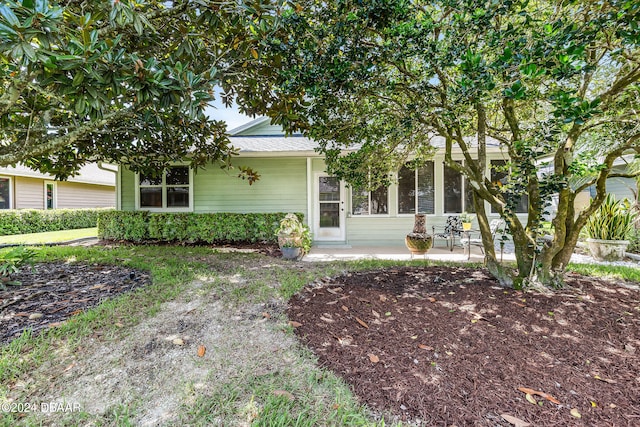 view of property hidden behind natural elements featuring a patio