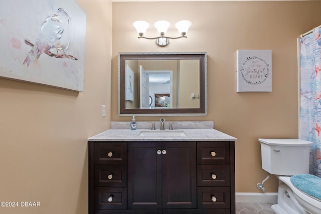 bathroom with toilet, vanity, and tile patterned floors