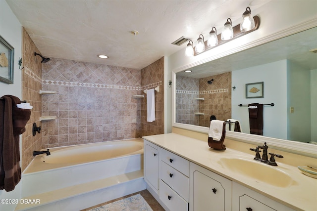 bathroom featuring vanity and tiled shower / bath combo