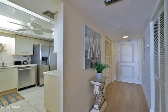 corridor with light hardwood / wood-style floors and sink