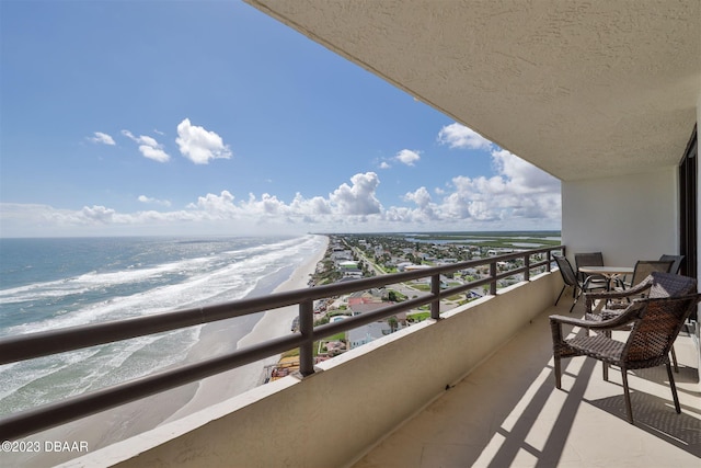 balcony featuring a water view and a view of the beach