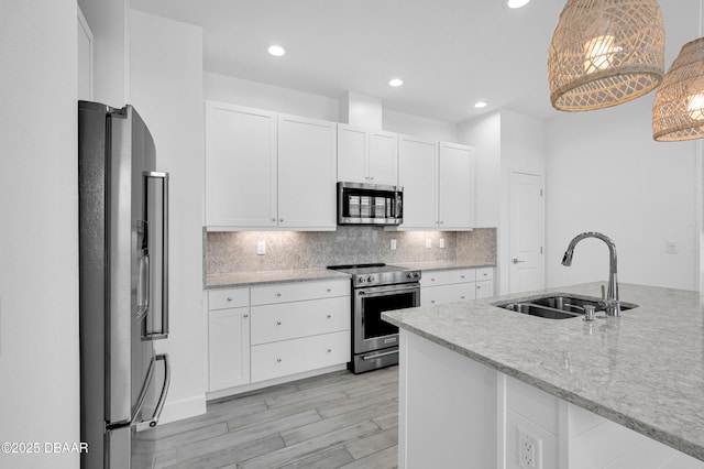 232 Ocean Hammock Loop, Daytona Beach, FL 32124 - kitchen featuring tasteful backsplash, a sink, light wood finished floors, white cabinets, and appliances with stainless steel finishes
