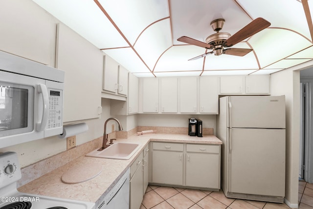 kitchen featuring white cabinets, white appliances, light tile patterned floors, and sink