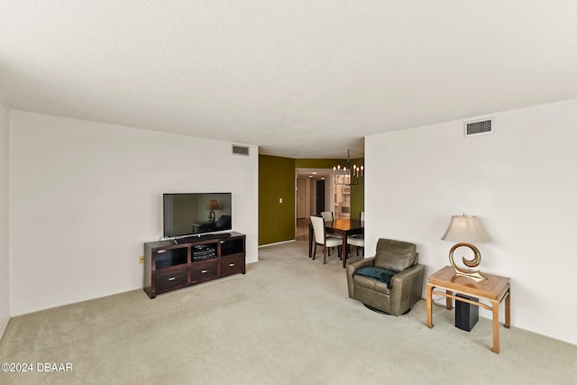 living area with carpet, a notable chandelier, and a textured ceiling