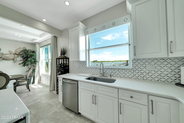 kitchen featuring white cabinetry, stainless steel dishwasher, a wealth of natural light, and sink