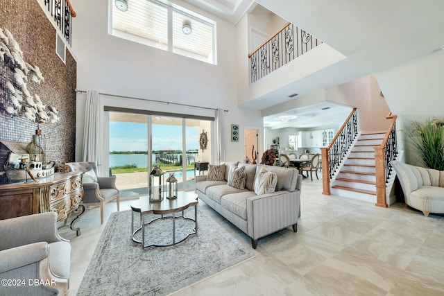 living room featuring a towering ceiling and a water view